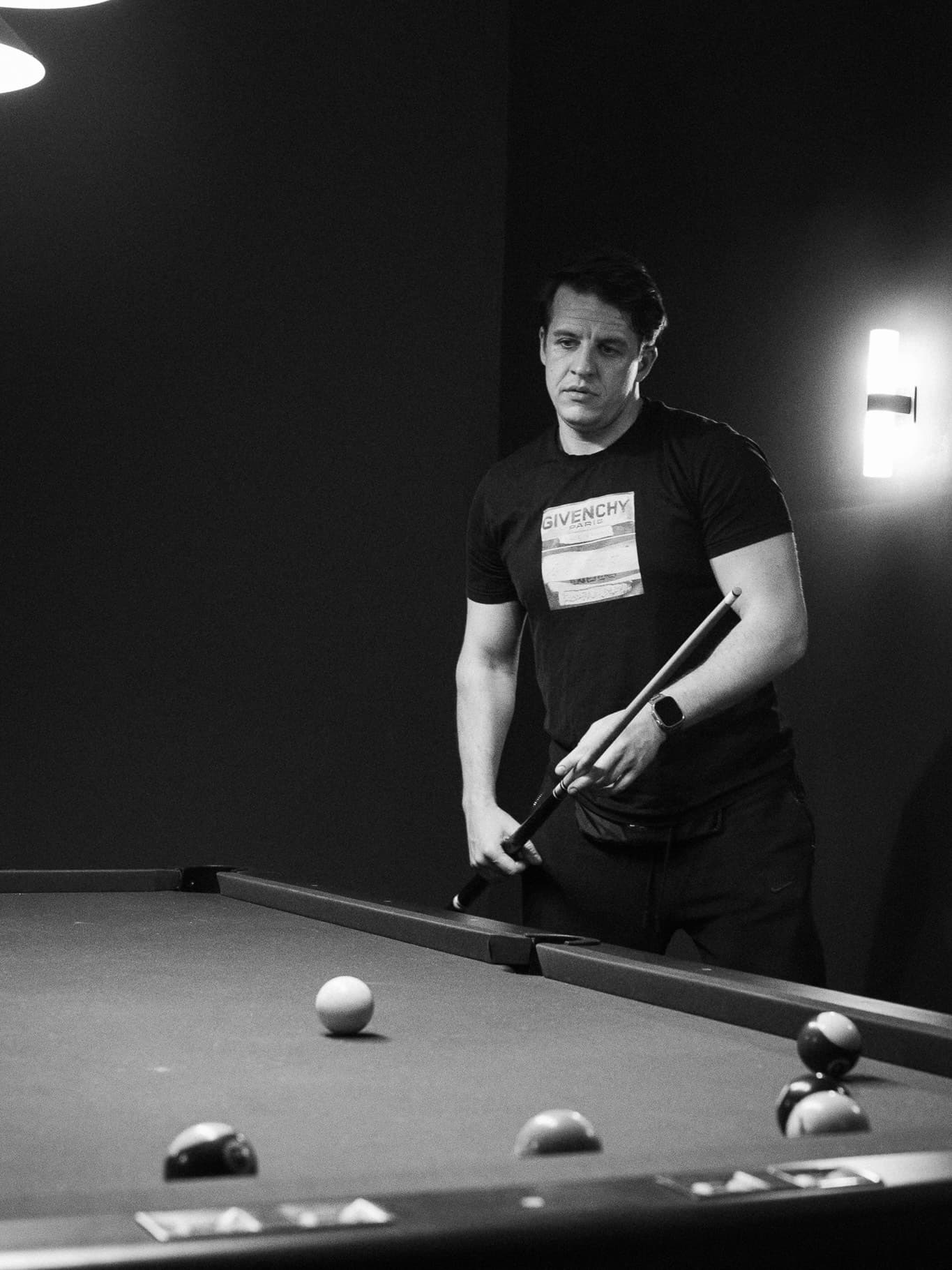 Black and white portrait of a man at a billiard table